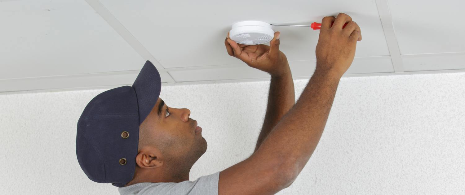 Picture of man installing smoke/carbon monoxide detector. Heating your home with wood or pellets can pose a risk of fire and smoke damage. American Restoration can help if you're home or commercial building has been affected by fire or smoke damage. Emergency fire and smoke damage cleanup, mitigation and restoration in Colorado.