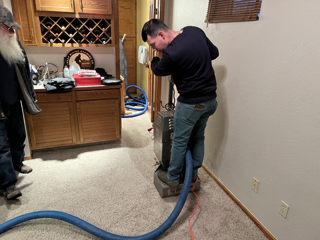 American Restoration of Pine Colorado extracting water from carpet and pad on a water damage job flooded house